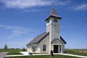 Little white chapel with gray roofing and windows in the top tower