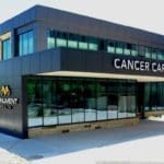 Exterior of the cancer care institute with black paneling and large black windows in the front.